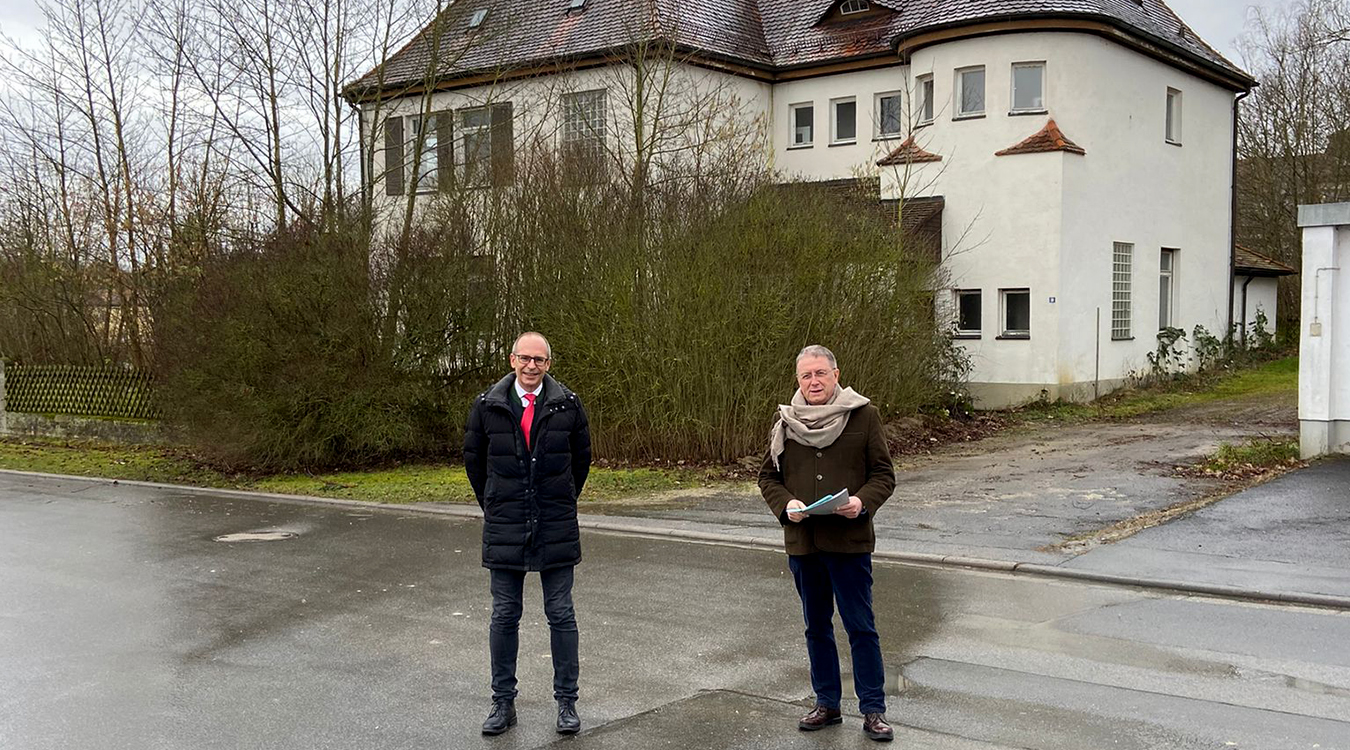 Landrat Christan Meißner und Bezirkstagspräsident Henry Schramm Zwei Männer stehen vor einem historischen Gebäude.