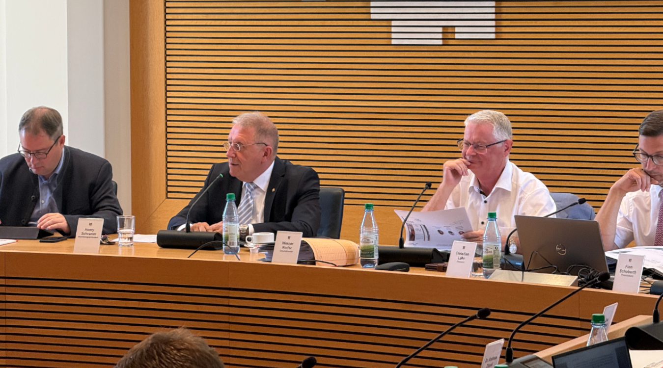 Letzte Sitzung des Bezirkstags vor der Sommerpause Vier Männer sitzen an einem Tisch