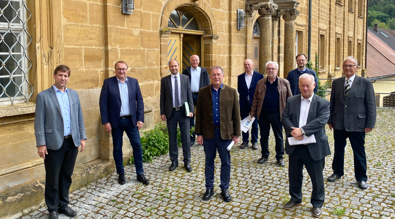 Das Bild zeigt zehn Männer, die vor dem Kloster Weißenohe stehen.