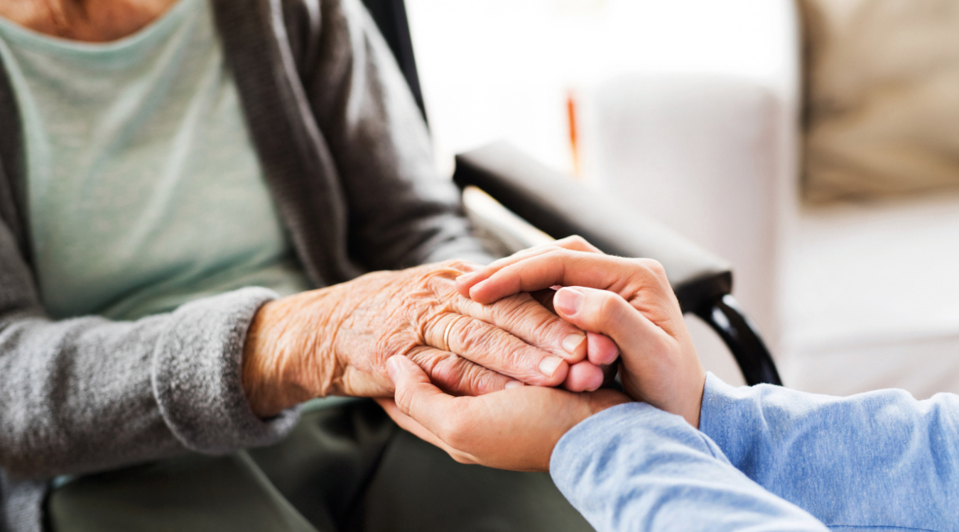 Fachtag Gerontopsychiatrie Die Hände eines jungen Menschen halten die Hände eines alten Menschen.