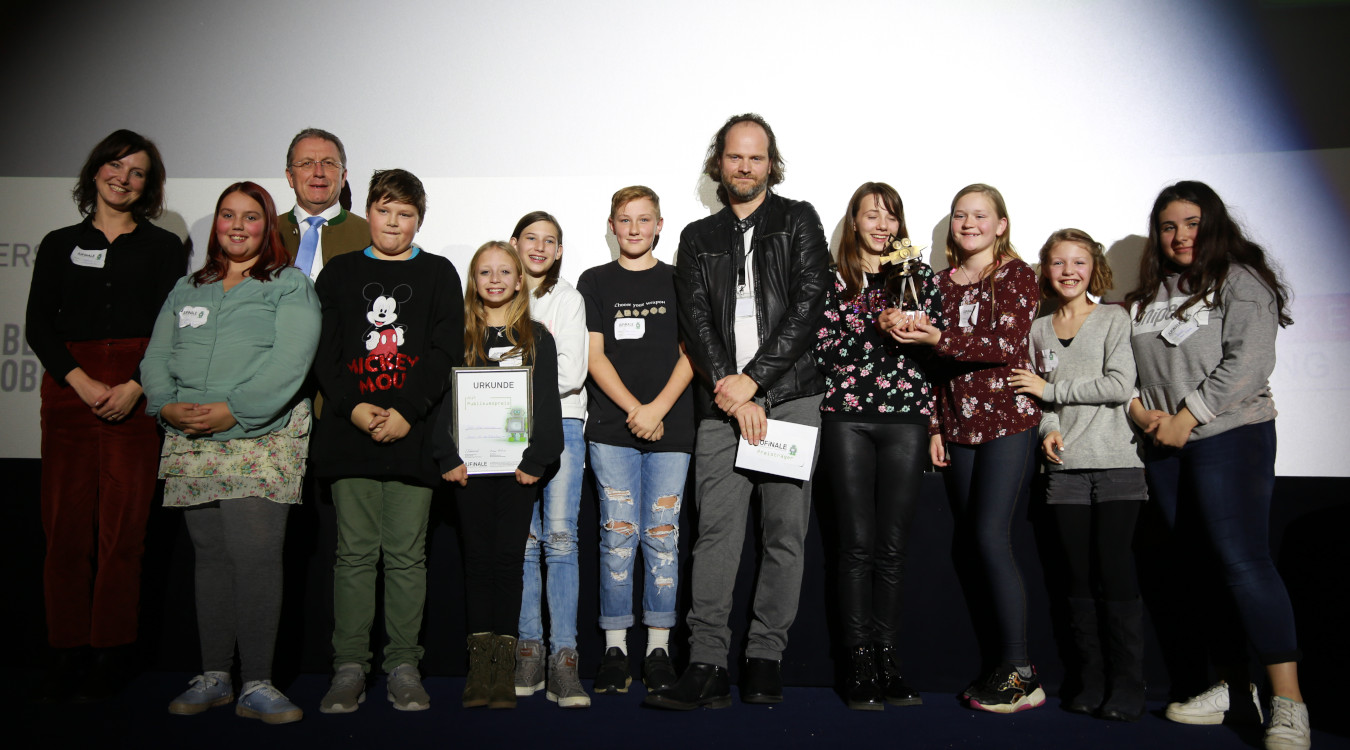 Das Bild zeigt die Gewinner bei der Jufinale 2019 in Coburg mit dem künstlerischen Paten Andreas Leopold Schadt und Bezirkstagspräsident Henry Schramm im Utopolis-Kino.