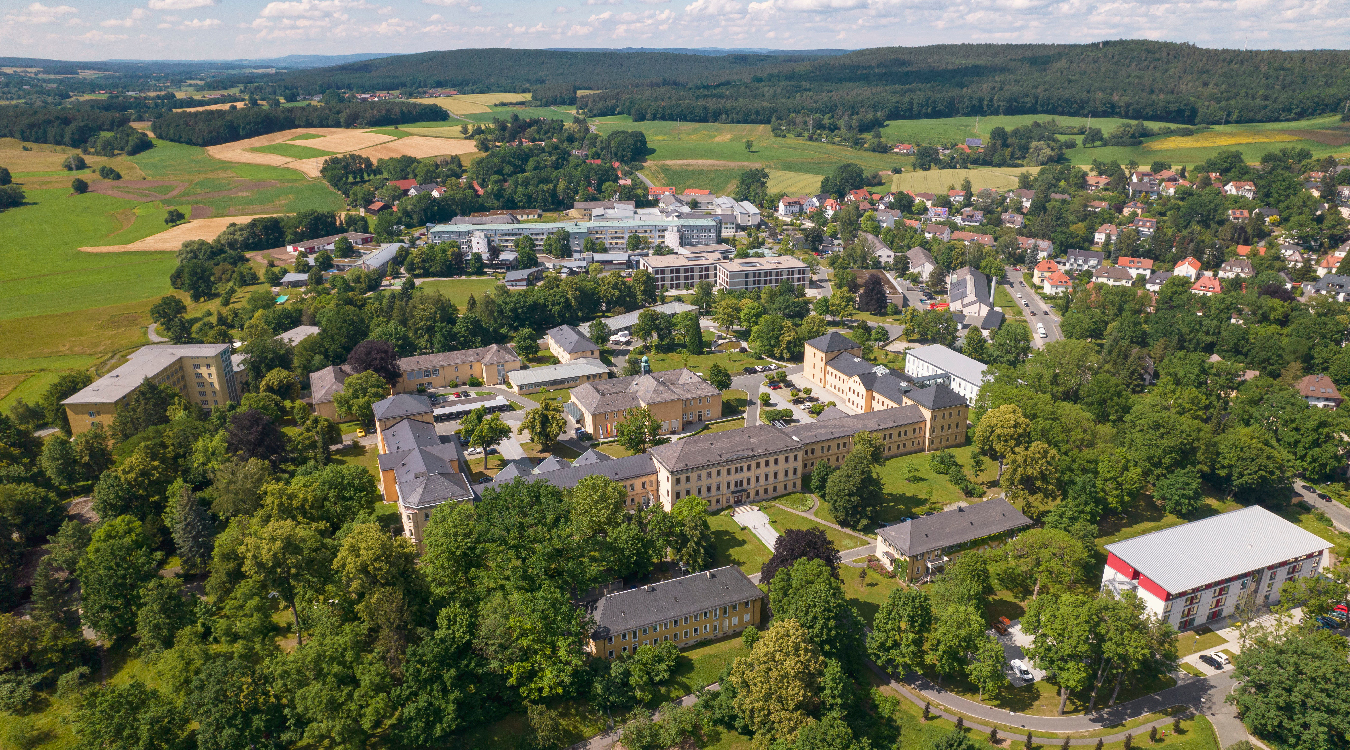Klinikstandort Bayreuth Blick auf mehrere Gebäude umgeben von Bäumen von oben