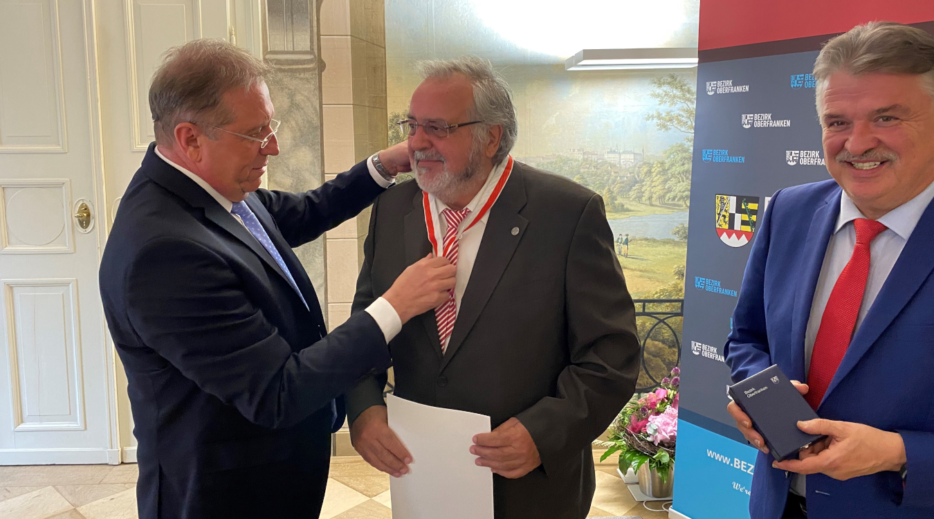 Bezirkstagspräsident Henry Schramm überreicht Klaus Förster die Ehrenmedaille in Silber. Daneben steht Landrat von Kulmbach Klaus Peter Söllner.