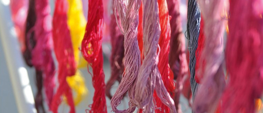 Stickgarne in unterschiedlichen Rosa-Tönen hängen nebeneinander.