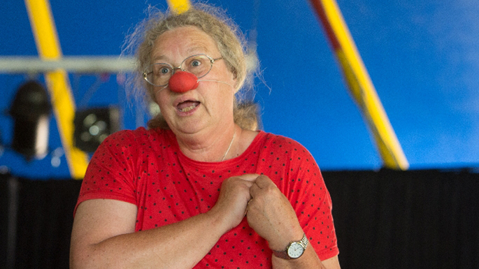 Eine Frau mit roter Clown-Nase zieht eine Grimasse