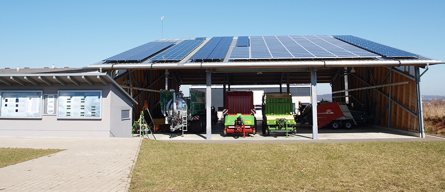 Auf dem Dach einer großen Maschinenhalle sind Photovoltaik-Module montiert.